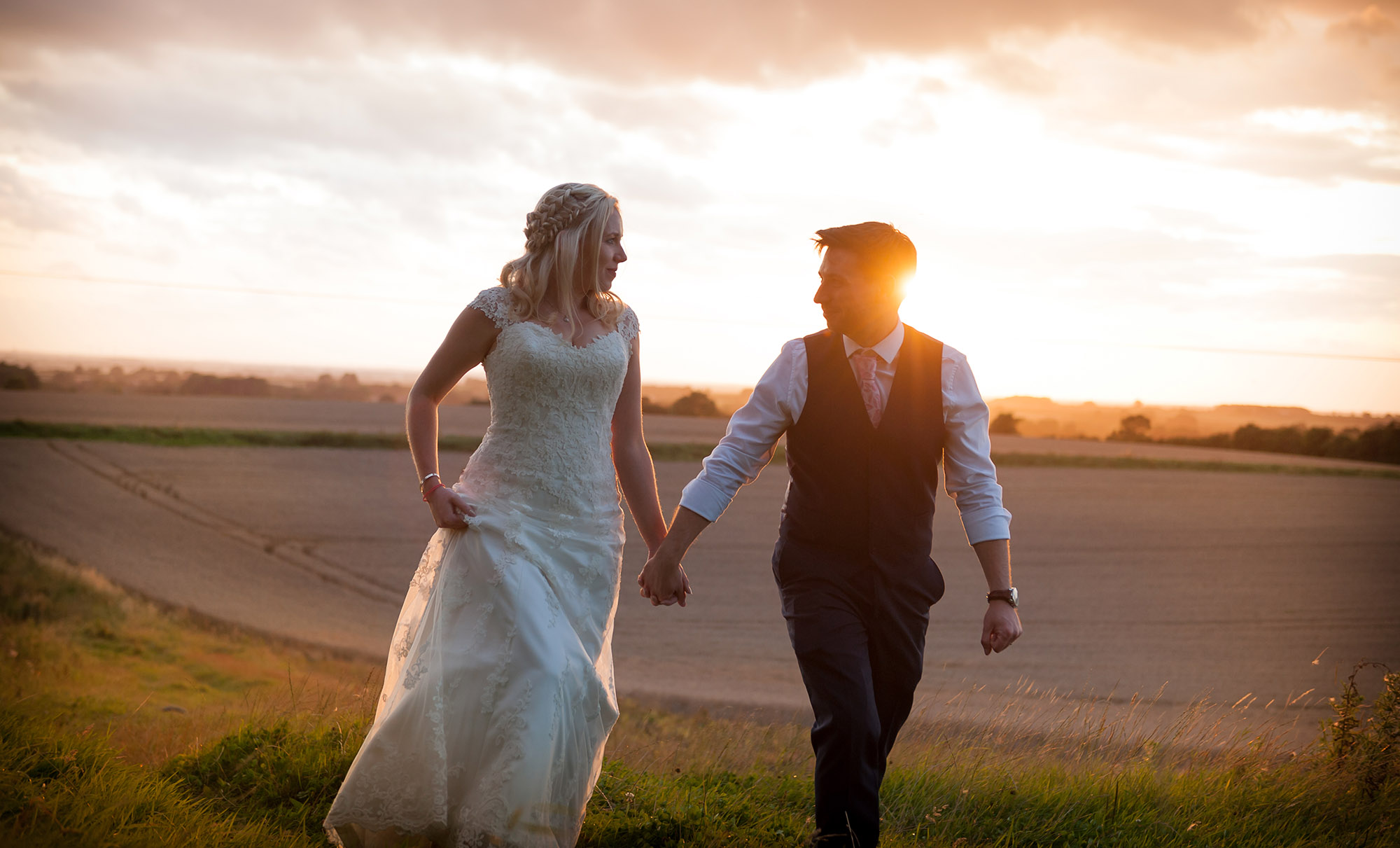 romantic wedding couple holding hands at sunset 